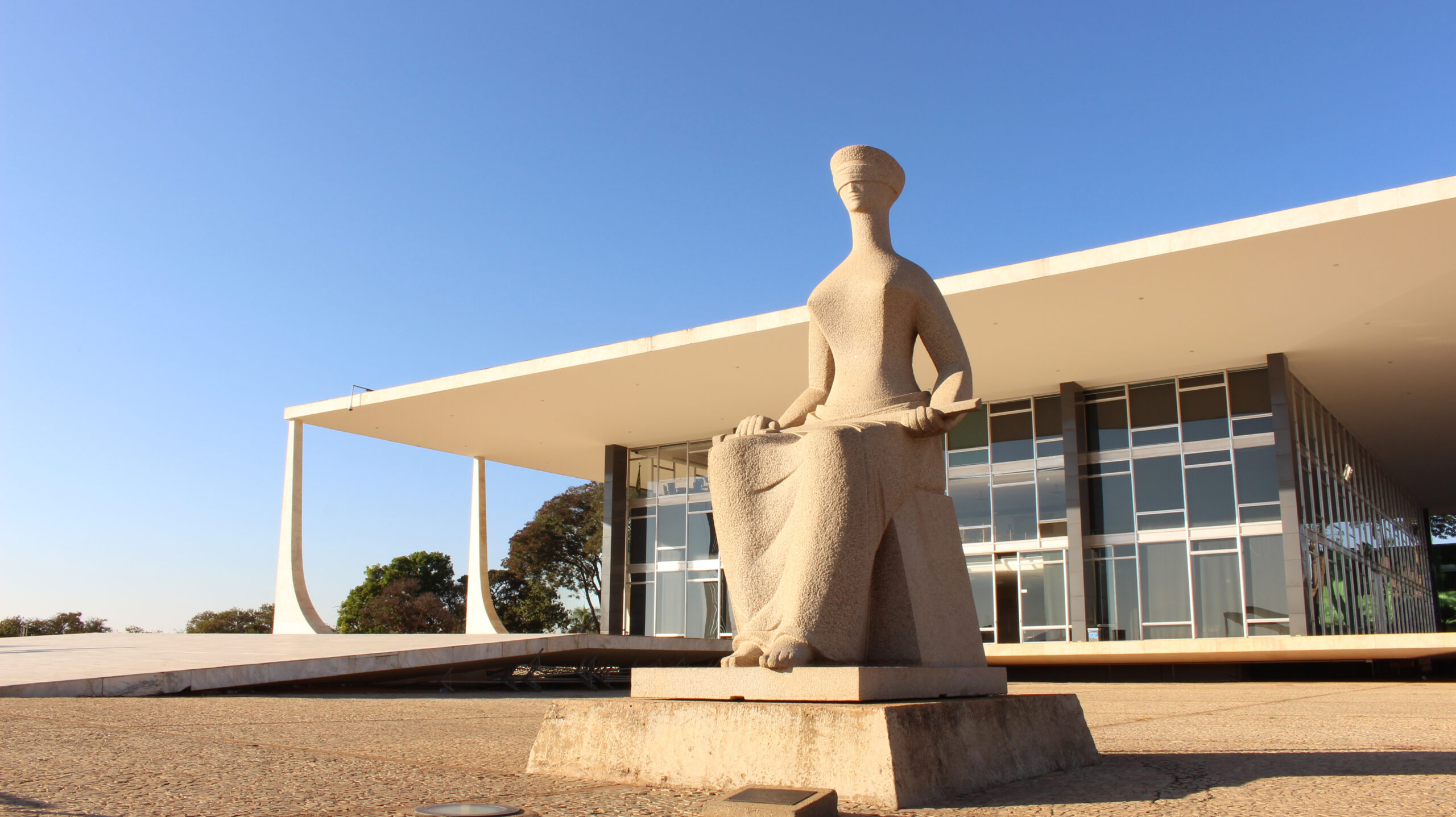 Statue of Justice in front of a modern building, symbolizing Brazil's efforts to regulate electoral disinformation in 2022.