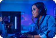 oung woman wearing headphones, playing a video game on a computer in a blue-lit room.