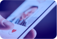 Close-up of a hand holding a smartphone with a dating app open, showing a profile with a heart icon.